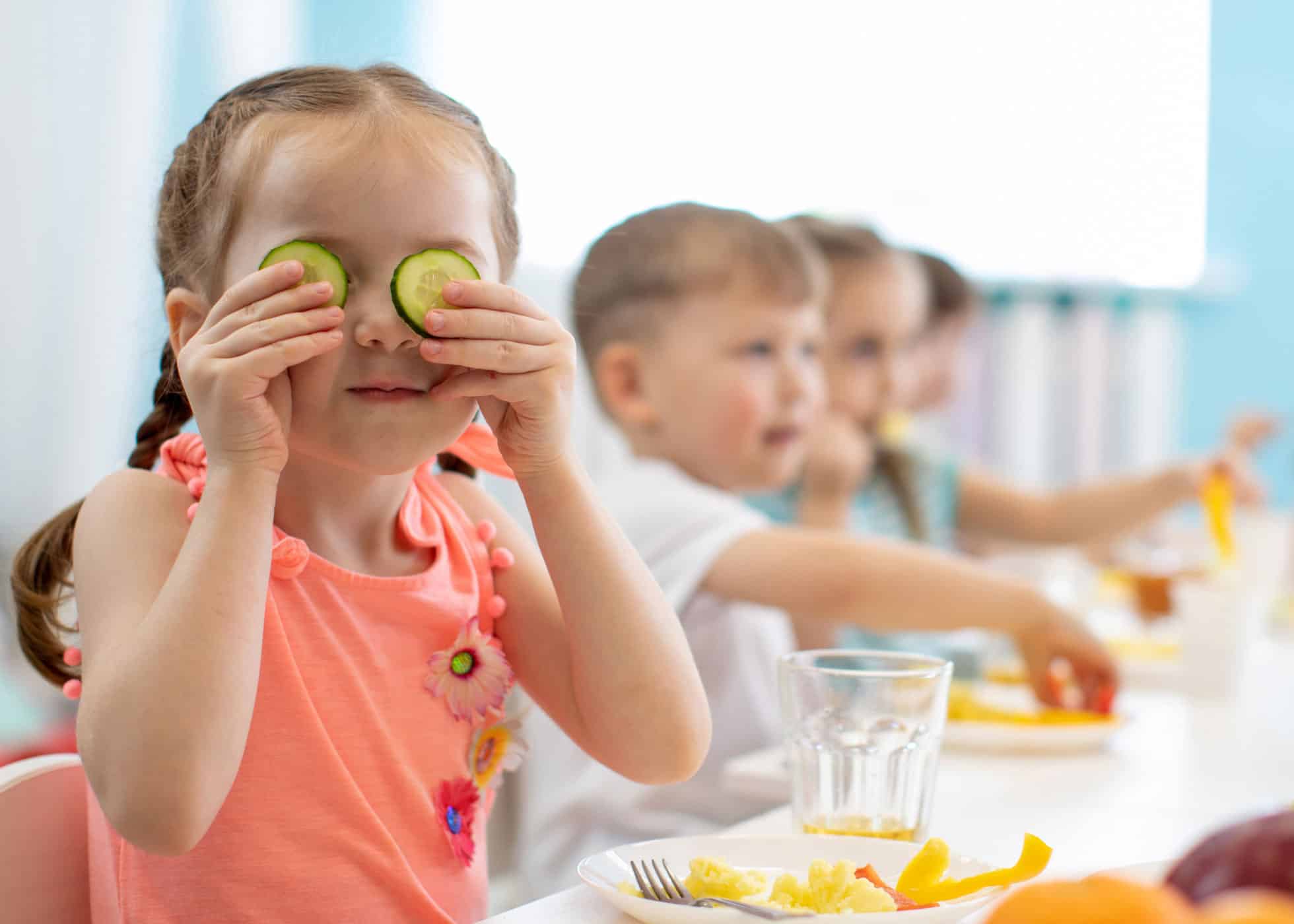 Child holding cucumbers eating healthy